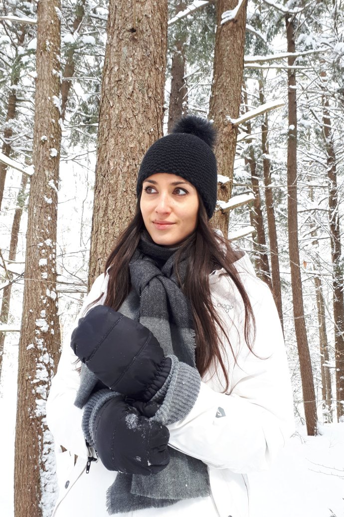 Woman wearing Hot Paws canada plush mitten in winter wonderland